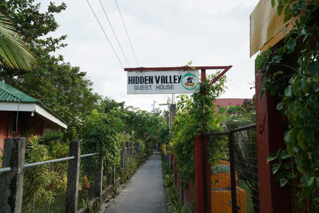 a narrow road with a signage called hidden valley guest house.