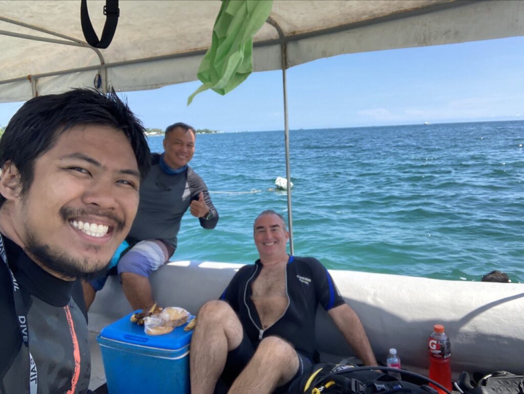 3 men on a boat and sea as the background