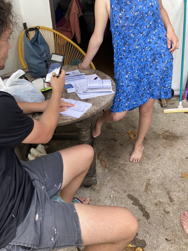 a table and a man writing in a notebook