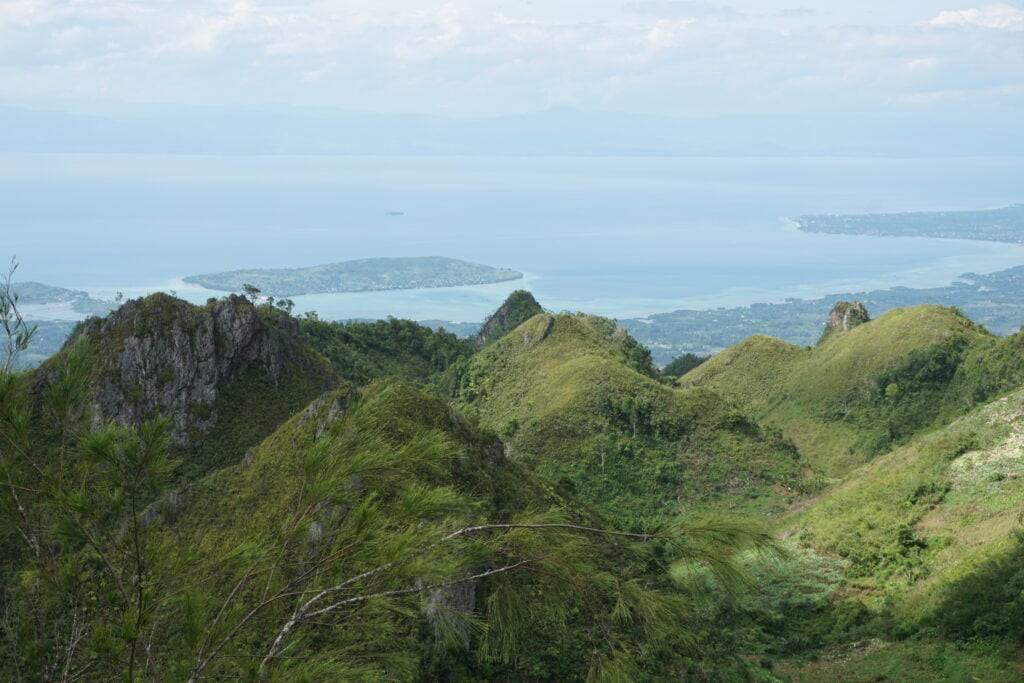 A green hill with sea as the background.