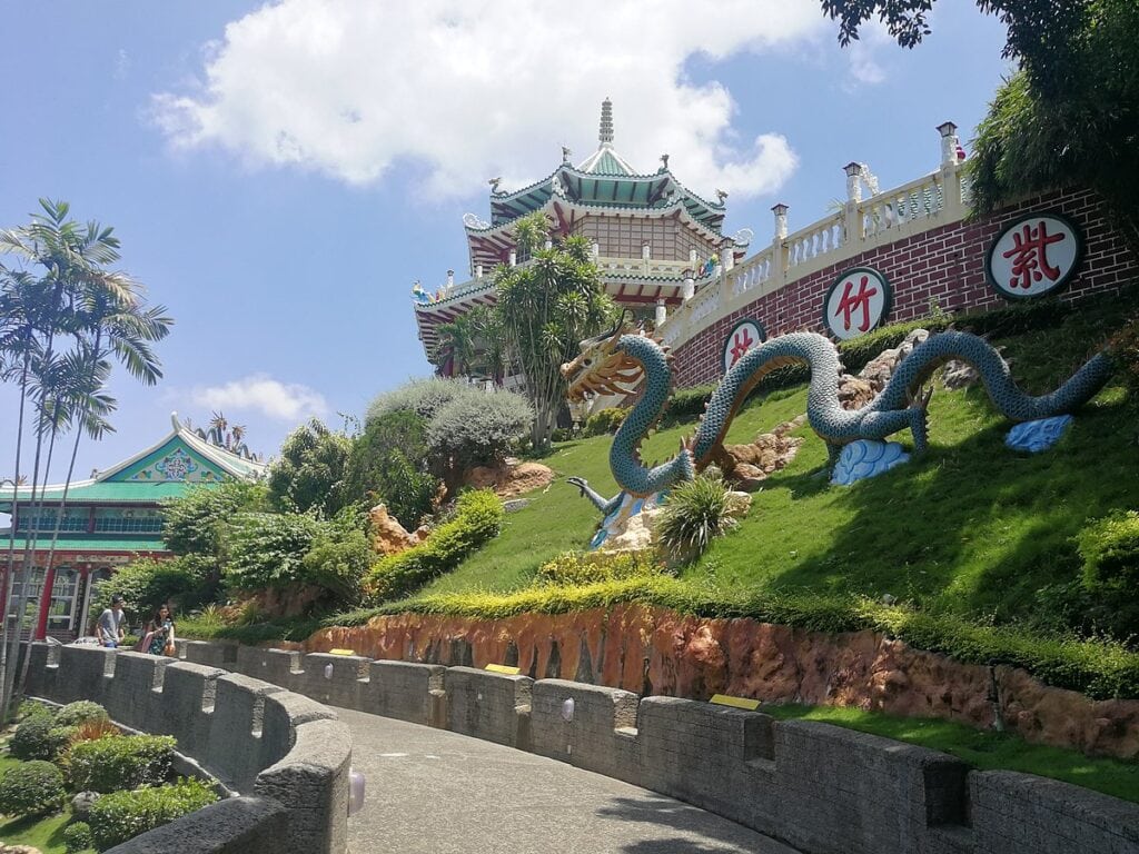 A Chinese temple with a dragon statue on the right side.