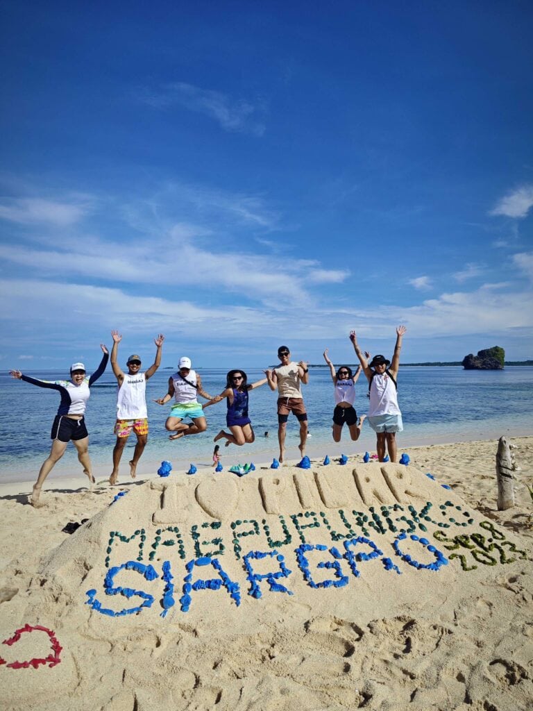 seven people jumping on a beach.
